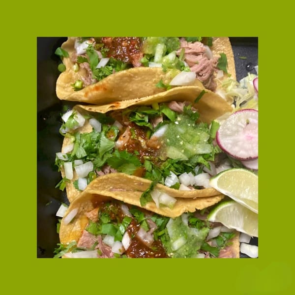 Three La Familia Callejas Mexican Food tacos with meat, cilantro, onions, salsa, and lime wedges.
